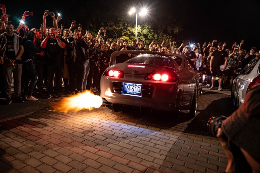 Toyota Supra z płomieniem z wydechu podczas nocnego zlotu